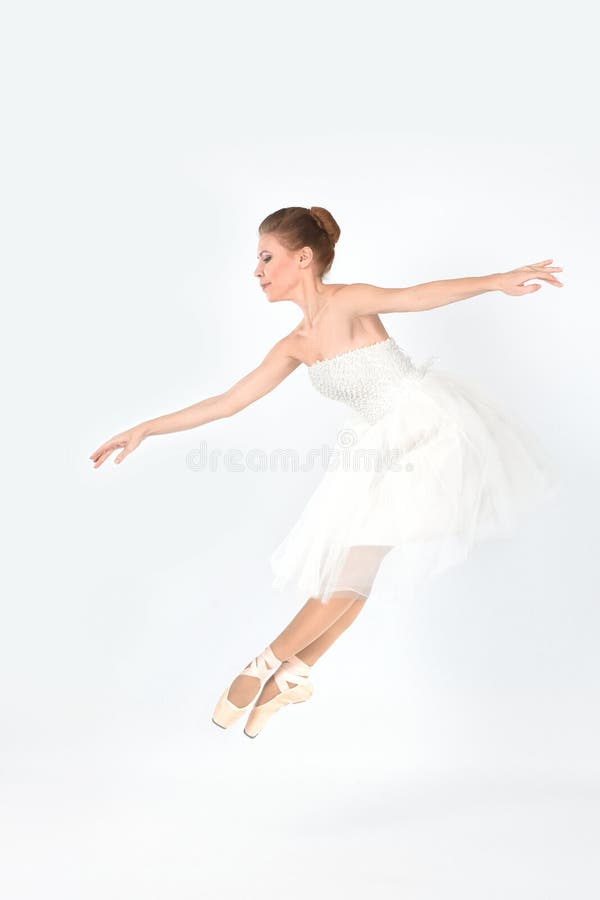 La ballerine dans les pointes et une robe danse sur un backgroun blanc image libre de droits La ballerine dans les pointes et une robe danse sur un backgroun blanc image libre de droits