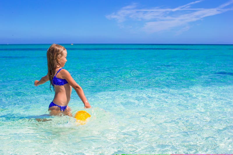 La bambina adorabile si diverte con il giocattolo della spiaggia immagine stock La bambina adorabile si diverte con il giocattolo della spiaggia immagine stock