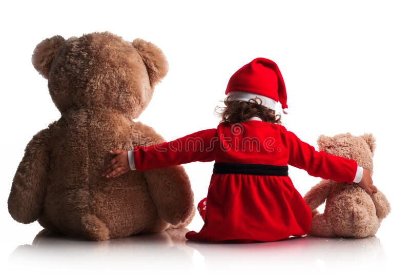 La bambina in cappello rosso di Santa di natale tiene il suo amico dei giocattoli dell'orsacchiotto Concetto di nuovo anno immagini stock La bambina in cappello rosso di Santa di natale tiene il suo amico dei giocattoli dell'orsacchiotto Concetto di nuovo anno immagini stock