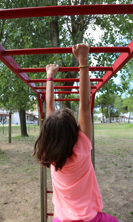 La bambina con una camicia rosa fa gli esercizi della palestra fotografia stock libera da diritti La bambina con una camicia rosa fa gli esercizi della palestra fotografia stock libera da diritti