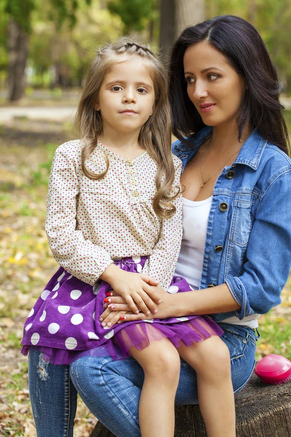 La bambina di Beautifal e la madre felice in autunno parcheggiano fotografia stock libera da diritti La bambina di Beautifal e la madre felice in autunno parcheggiano fotografia stock libera da diritti
