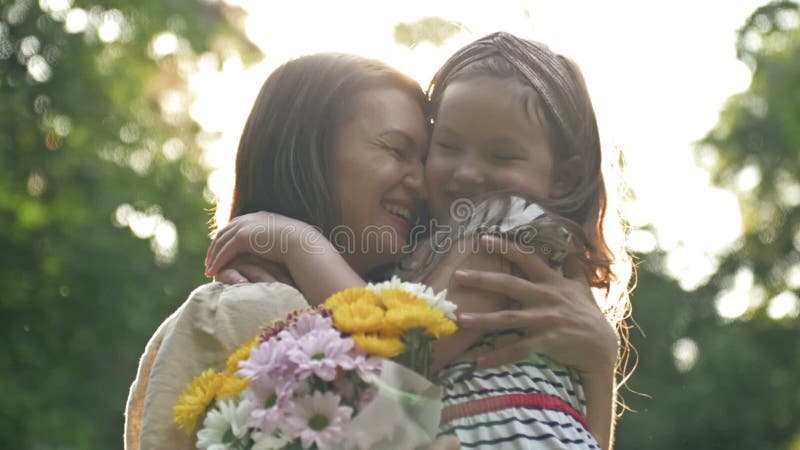 La bambina dà dei fiori a sua madre. bella famiglia insieme. giornata estiva. ritratto familiare. felice maternità. godere