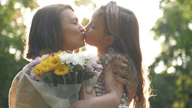 La bambina dà dei fiori a sua madre. bella famiglia insieme. giornata estiva. ritratto familiare. felice maternità. godere