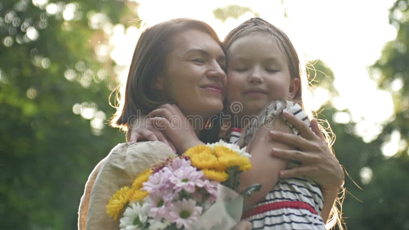 La bambina dà dei fiori a sua madre. bella famiglia insieme. giornata estiva. ritratto familiare. felice maternità. godere