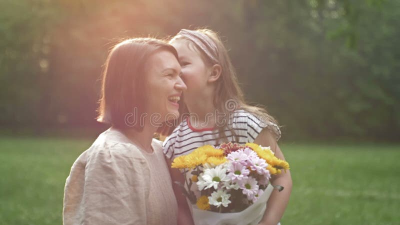 La bambina dà dei fiori a sua madre. bella famiglia insieme. giornata estiva. ritratto familiare. felice maternità. godere