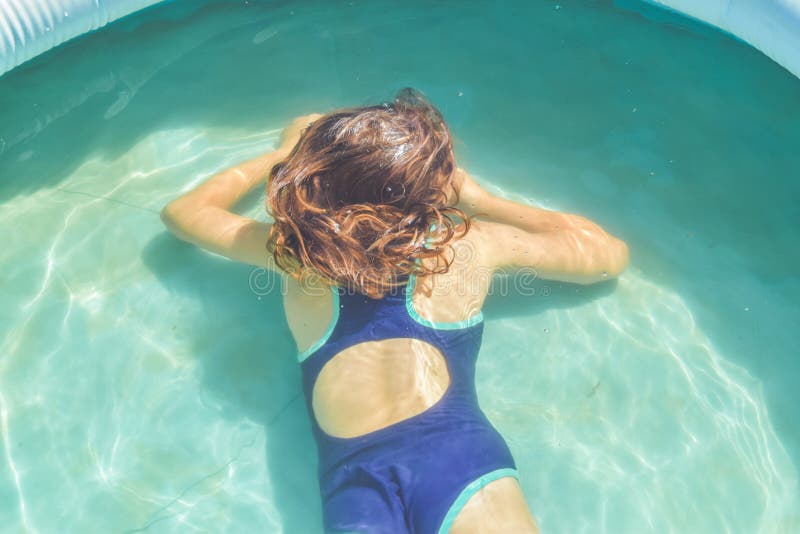La bambina sta spaccando in piscina per strada immagini stock