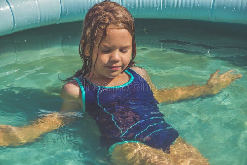 La bambina sta spaccando in piscina per strada immagine stock