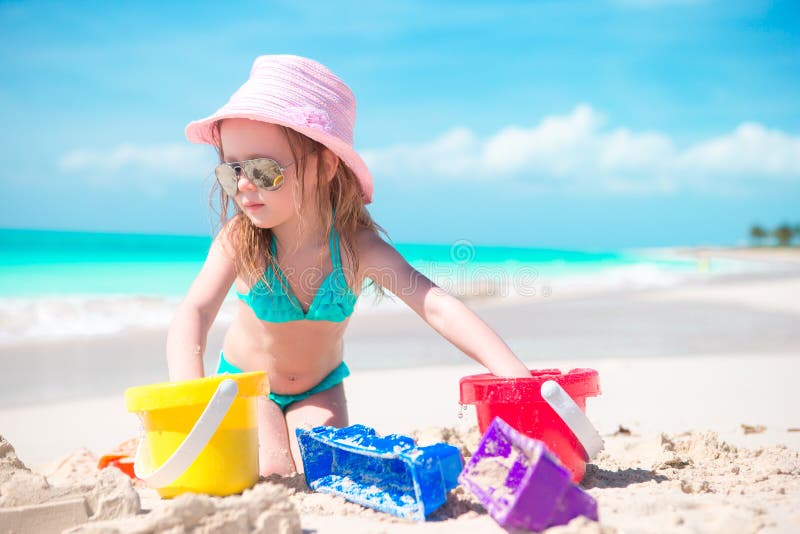 La bambina sveglia che gioca con la spiaggia gioca sulla spiaggia immagini stock libere da diritti La bambina sveglia che gioca con la spiaggia gioca sulla spiaggia immagini stock libere da diritti