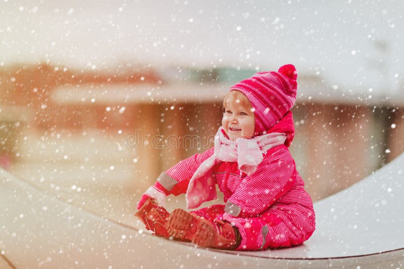 La bambina sveglia gode della prima neve nella città, divertimento dell'inverno