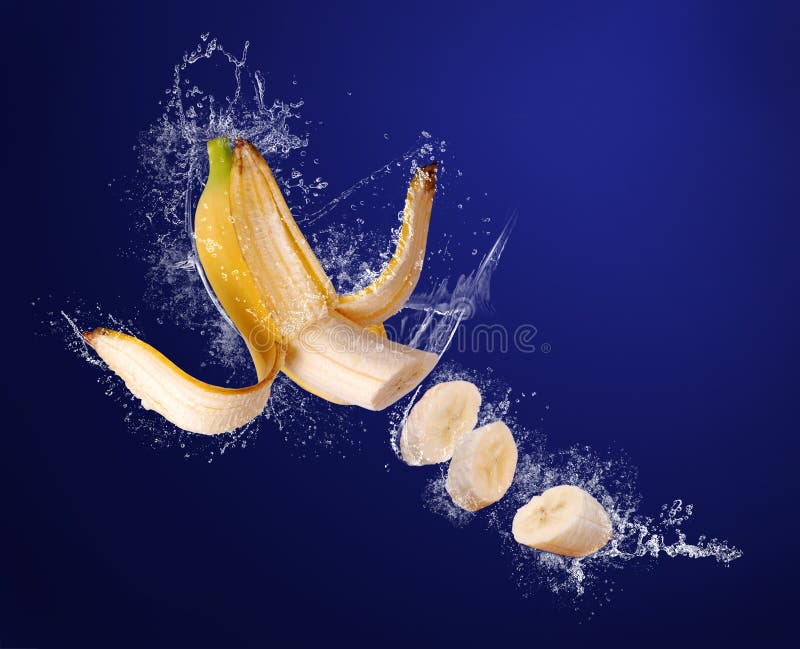 La banana affettata il colore giallo in acqua spruzza fotografie stock libere da diritti La banana affettata il colore giallo in acqua spruzza fotografie stock libere da diritti