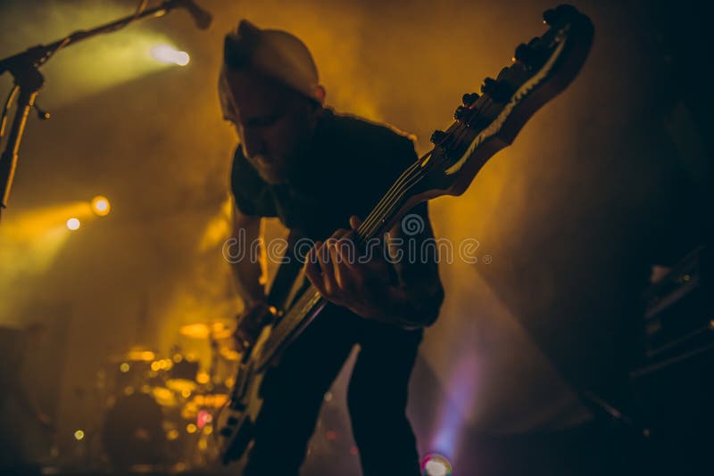 La banda rock esegue in scena Il chitarrista gioca da solo Siluetta del giocatore di chitarra nell'azione in scena davanti alla f immagini stock La banda rock esegue in scena Il chitarrista gioca da solo Siluetta del giocatore di chitarra nell'azione in scena davanti alla f immagini stock