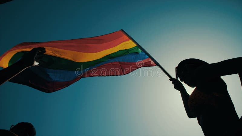 La bandera del arco iris que agita durante un desfile de orgullo