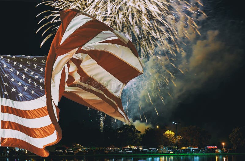 La bandiera americana che ondeggia in fuochi d'artificio gialli verdi rossi scintillanti di celebrazione sopra il cielo stellato immagine stock La bandiera americana che ondeggia in fuochi d'artificio gialli verdi rossi scintillanti di celebrazione sopra il cielo stellato immagine stock