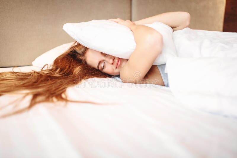 La bella donna abbraccia il cuscino, svegliante immagini stock La bella donna abbraccia il cuscino, svegliante immagini stock