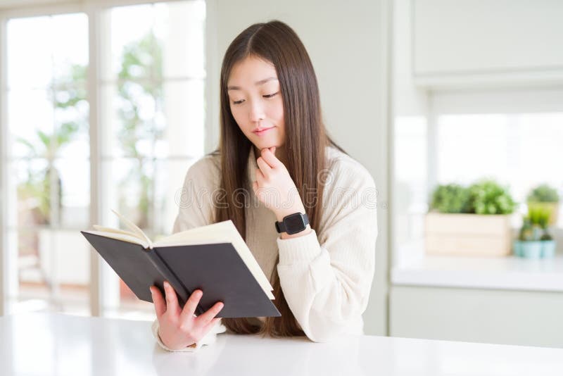 Beautiful Asian woman reading a book serious face thinking about question, very confused idea. Beautiful Asian woman reading a book serious face thinking about question, very confused idea