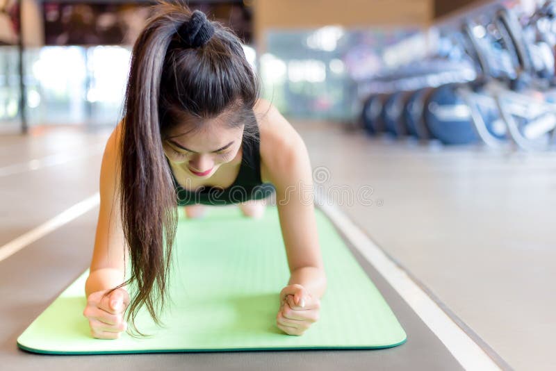 La bella donna attraente sta facendo l'esercizio su una stuoia di yoga a così fotografie stock libere da diritti La bella donna attraente sta facendo l'esercizio su una stuoia di yoga a così fotografie stock libere da diritti