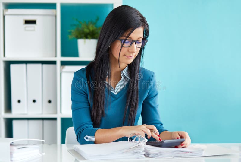 La bella donna di affari calcola la tassa fotografie stock libere da diritti La bella donna di affari calcola la tassa fotografie stock libere da diritti