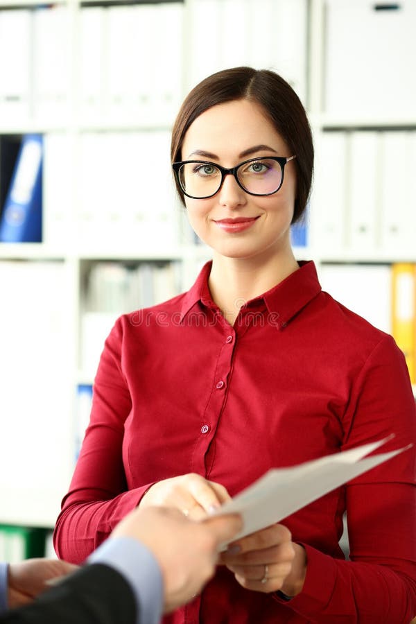 La bella donna di affari sorridente indossa i vetri per tenere in carte finanziarie di armi immagine stock libera da diritti La bella donna di affari sorridente indossa i vetri per tenere in carte finanziarie di armi immagine stock libera da diritti