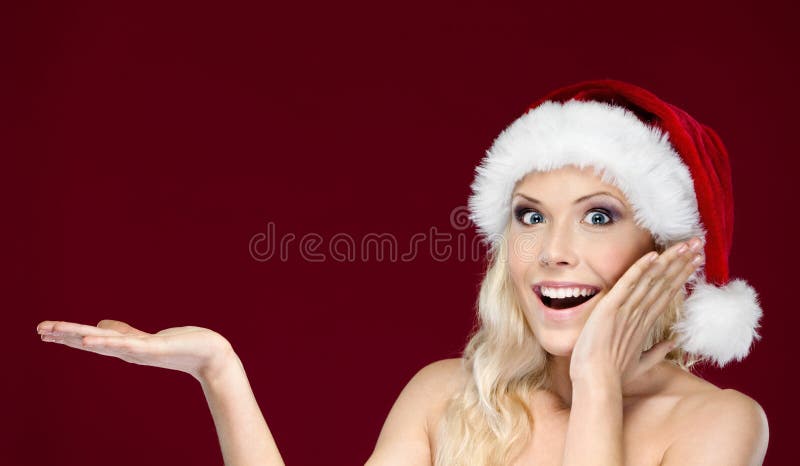La bella donna in protezione di natale gestures la palma in su fotografia stock libera da diritti La bella donna in protezione di natale gestures la palma in su fotografia stock libera da diritti