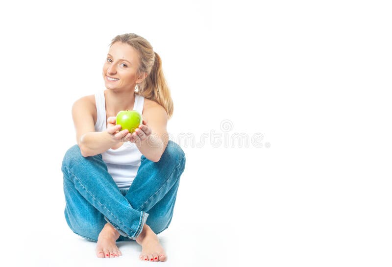 La bella donna sta mangiando la mela su fondo bianco E immagini stock libere da diritti La bella donna sta mangiando la mela su fondo bianco E immagini stock libere da diritti