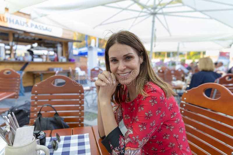 La bella donna turistica in alimento aspettante del ristorante locale si siede fotografia stock libera da diritti La bella donna turistica in alimento aspettante del ristorante locale si siede fotografia stock libera da diritti