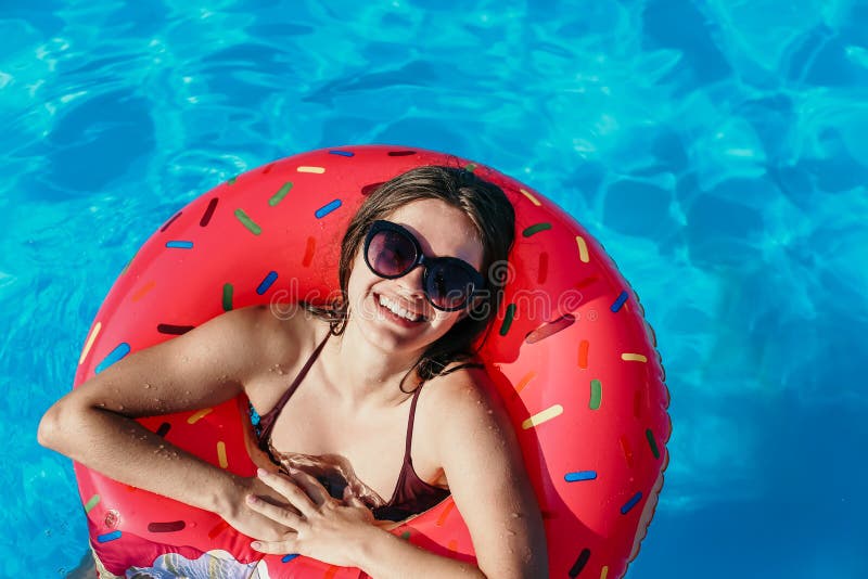 La bella giovane donna con il cerchio rosa della ciambella ha resto fotografie stock La bella giovane donna con il cerchio rosa della ciambella ha resto fotografie stock