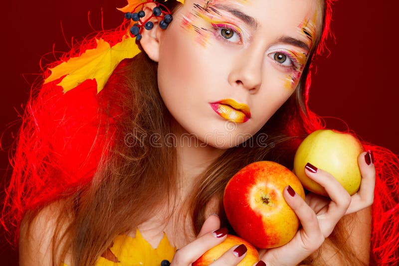 La bella giovane donna con l'autunno compone la posa nello studio più immagine stock La bella giovane donna con l'autunno compone la posa nello studio più immagine stock