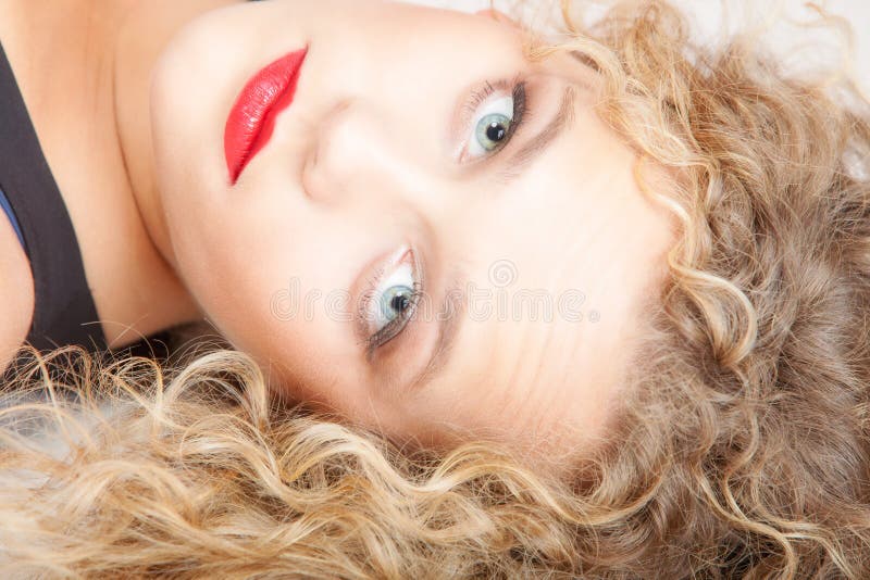 La bella ragazza bionda del ritratto compone la menzogne sul colpo dello studio del pavimento fotografie stock La bella ragazza bionda del ritratto compone la menzogne sul colpo dello studio del pavimento fotografie stock