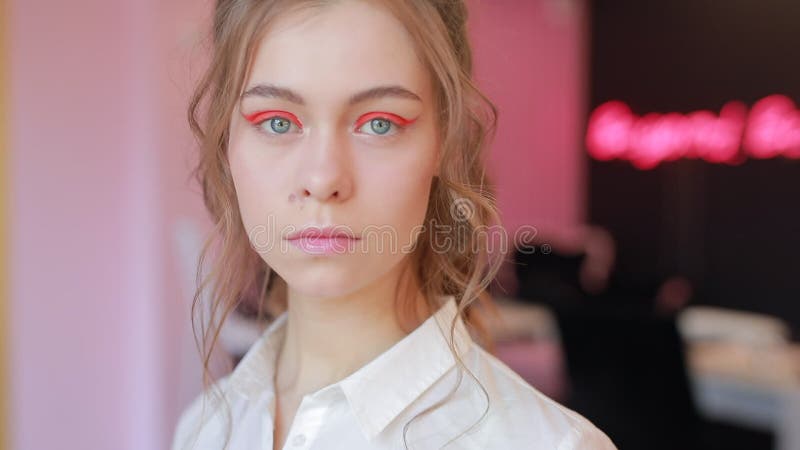 La bella ragazza dimostra il suo trucco luminoso sconosciuto della molla