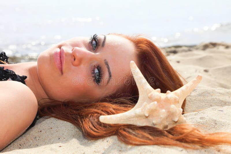 La bella ragazza si trova sulla costa di mare con la vacanza della natura delle coperture immagini stock