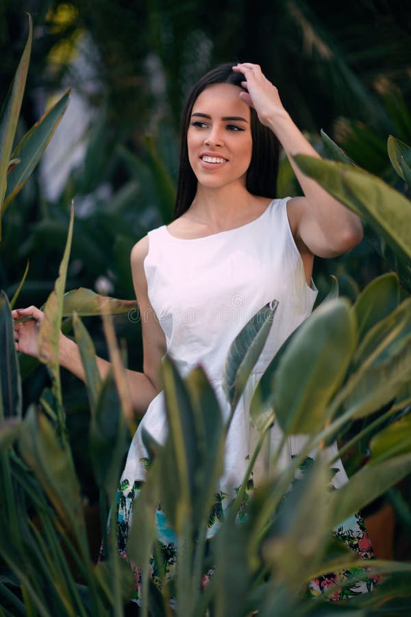 La bella ragazza sta rilassandosi su sfondo naturale Una giovane donna allegra sul fondo delle foglie verdi Una signora alla moda fotografie stock La bella ragazza sta rilassandosi su sfondo naturale Una giovane donna allegra sul fondo delle foglie verdi Una signora alla moda fotografie stock