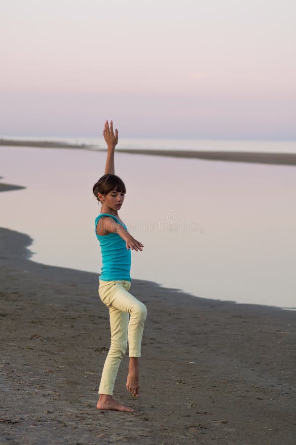 La belle adolescente est sur le point de faire une roue gymnastique de foret sur le fond de la mer au coucher du soleil, images stock La belle adolescente est sur le point de faire une roue gymnastique de foret sur le fond de la mer au coucher du soleil, images stock
