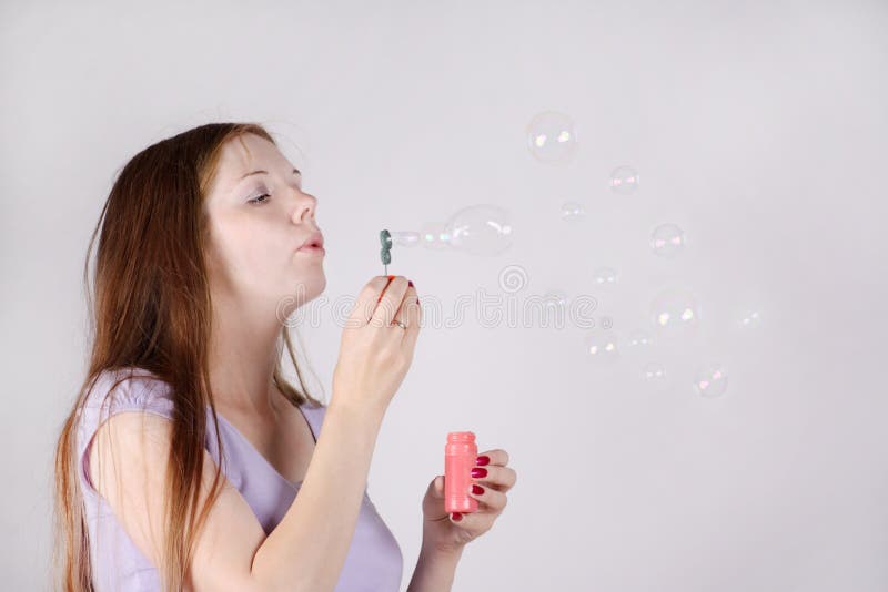 La belle femme souffle des bulles de savon image stock La belle femme souffle des bulles de savon image stock