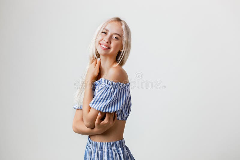 La belle fille blonde amicale joyeuse dans l'équipement d'été sourit s'étreignant, au-dessus du fond blanc émotions photographie stock La belle fille blonde amicale joyeuse dans l'équipement d'été sourit s'étreignant, au-dessus du fond blanc émotions photographie stock