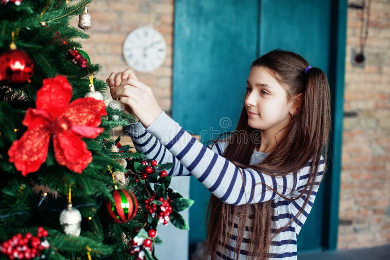La belle fille de l'adolescence décore l'arbre de Noël dans la maison T images libres de droits La belle fille de l'adolescence décore l'arbre de Noël dans la maison T images libres de droits