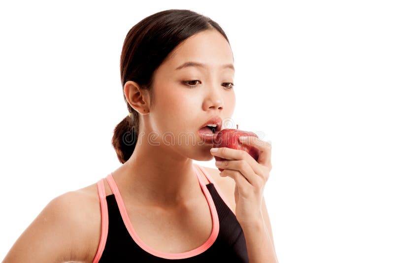 La belle fille en bonne santé asiatique mangent la pomme rouge
