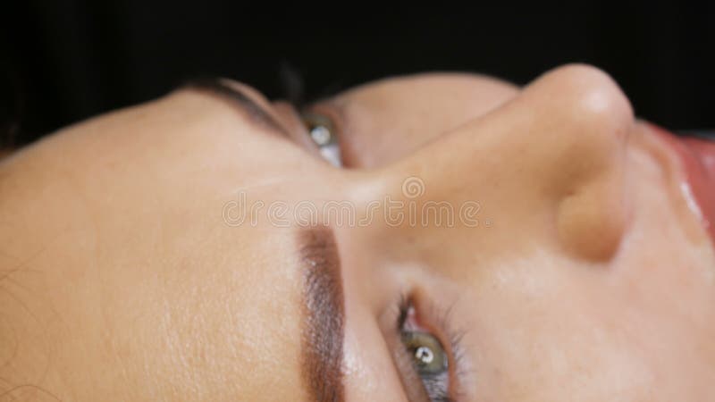 La belle jeune femme avec le maquillage permanent de la lèvre et le tatouage microblading de sourcil se retrouve avec un salon de banque de vidéos