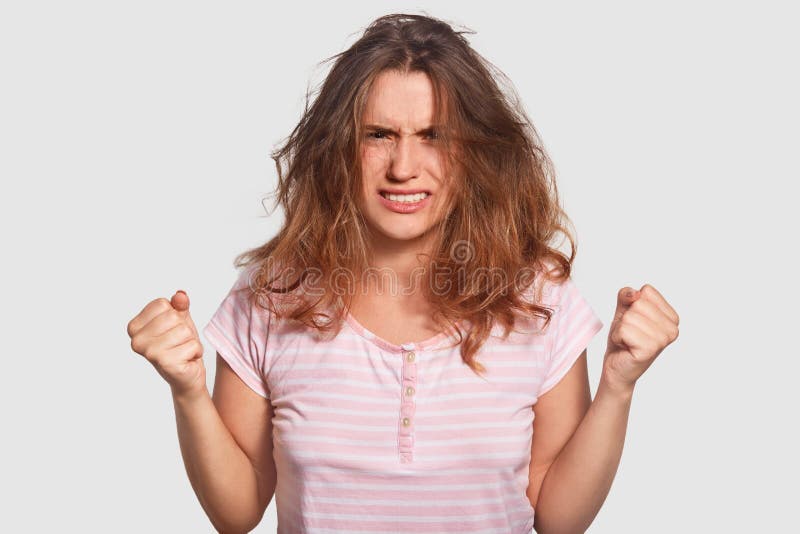La belle jeune femme contrariée serre des poings avec colère, sembler irritée, a le désordre sur la tête, se sent furieuse quand photographie stock libre de droits La belle jeune femme contrariée serre des poings avec colère, sembler irritée, a le désordre sur la tête, se sent furieuse quand photographie stock libre de droits