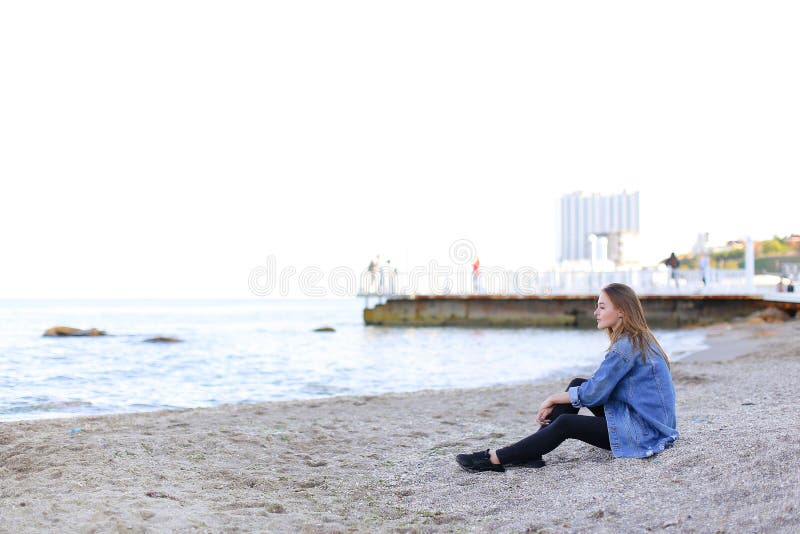 La belle jeune femme détend se reposer sur la plage et apprécie la vue o images libres de droits La belle jeune femme détend se reposer sur la plage et apprécie la vue o images libres de droits