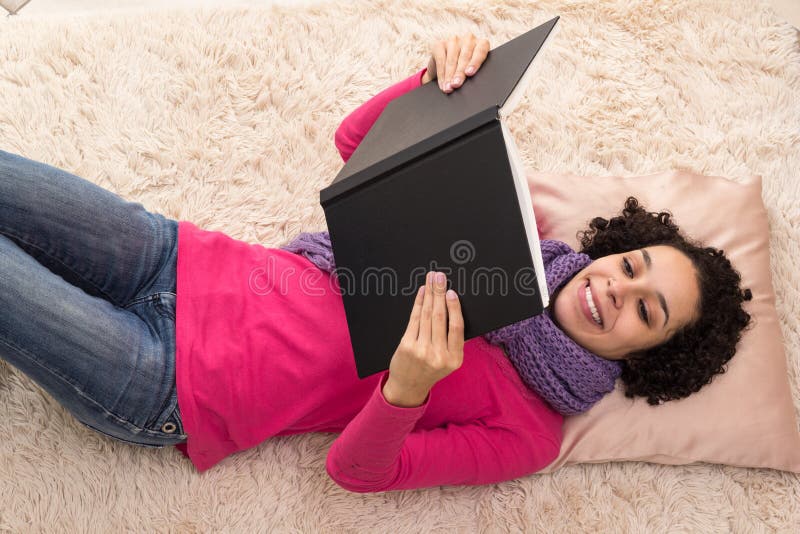 La belle jeune femme lit un livre avec une couverture noire images stock La belle jeune femme lit un livre avec une couverture noire images stock