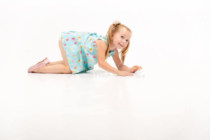 la belle petite fille blonde mignonne rampe sur ses genoux, elle se repose avec le leur photographie stock libre de droits la belle petite fille blonde mignonne rampe sur ses genoux, elle se repose avec le leur photographie stock libre de droits