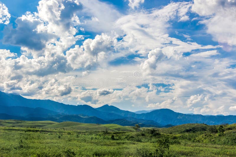 La bellezza nel paesaggio estivo della natura Cielo Blu Straordinario Con Belle Nuvole, Montagne, Campo Con L'Erba Verde Vista Ru immagine stock La bellezza nel paesaggio estivo della natura Cielo Blu Straordinario Con Belle Nuvole, Montagne, Campo Con L'Erba Verde Vista Ru immagine stock