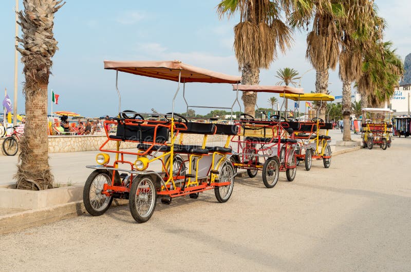 La bicicleta del carrito para el alquiler para los turistas parqueó cerca de la playa en San Vito Lo Capo imagen de archivo La bicicleta del carrito para el alquiler para los turistas parqueó cerca de la playa en San Vito Lo Capo imagen de archivo