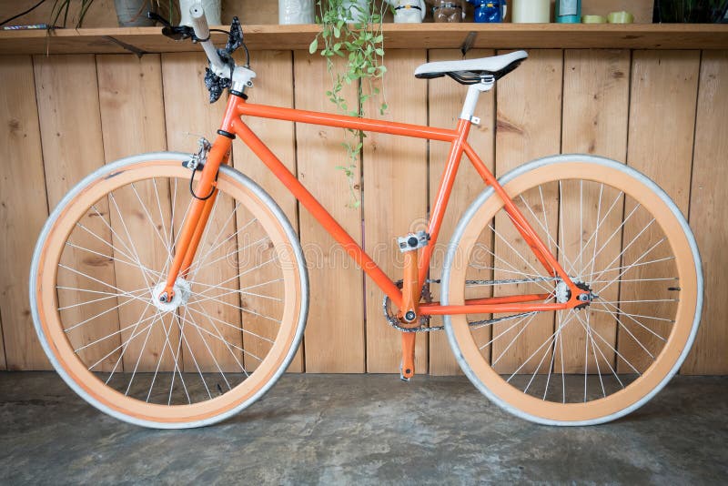 La bicyclette fixe de vitesse garée avec le mur en bois, se ferment vers le haut de l'image images libres de droits La bicyclette fixe de vitesse garée avec le mur en bois, se ferment vers le haut de l'image images libres de droits