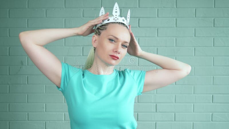 La blonde de femme avec des tresses Afro et une longue queue de cheval met sur une couronne blanche en cuir banque de vidéos