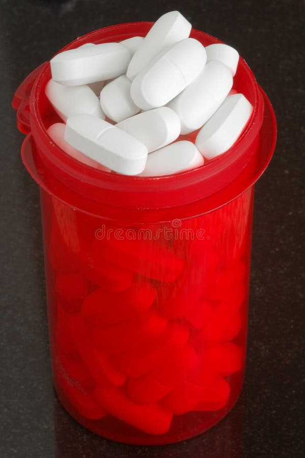 Red prescription bottle filled with white calcium tablets. Red prescription bottle filled with white calcium tablets.