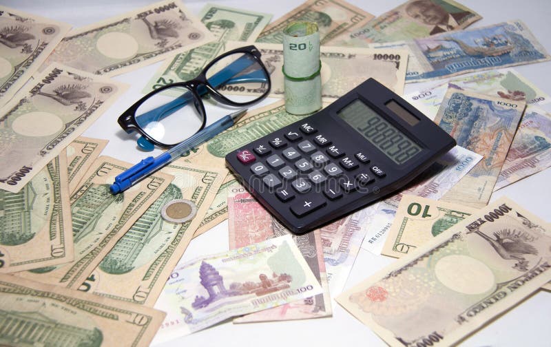 La calculatrice noire et le stylo bille et les lunettes bleus avec les billets de banque thaïlandais de petit pain emploient une image libre de droits La calculatrice noire et le stylo bille et les lunettes bleus avec les billets de banque thaïlandais de petit pain emploient une image libre de droits
