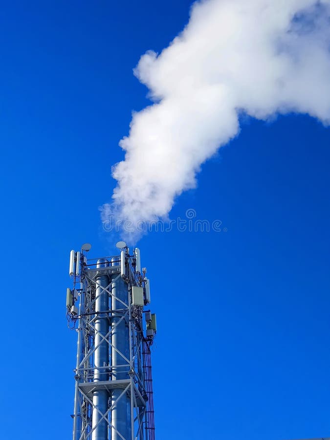 La caldaia convoglia con fumo sui precedenti del cielo blu fotografia stock libera da diritti La caldaia convoglia con fumo sui precedenti del cielo blu fotografia stock libera da diritti