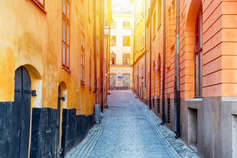 La calle estrecha del guijarro con las casas medievales amarillas centro histórico de Gamla Stan del viejo de Estocolmo en el día imágenes de archivo libres de regalías La calle estrecha del guijarro con las casas medievales amarillas centro histórico de Gamla Stan del viejo de Estocolmo en el día imágenes de archivo libres de regalías