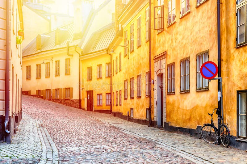 La calle estrecha del guijarro con una bicicleta y casas medievales amarillas centro histórico de Gamla Stan del viejo de Estocol imágenes de archivo libres de regalías La calle estrecha del guijarro con una bicicleta y casas medievales amarillas centro histórico de Gamla Stan del viejo de Estocol imágenes de archivo libres de regalías
